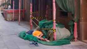 Un turista duerme en unas obras de La Barceloneta / Twitter