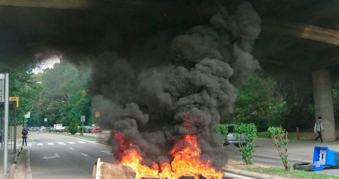Un contenedor quemado en medio del acceso por carretera a la UAB / CG
