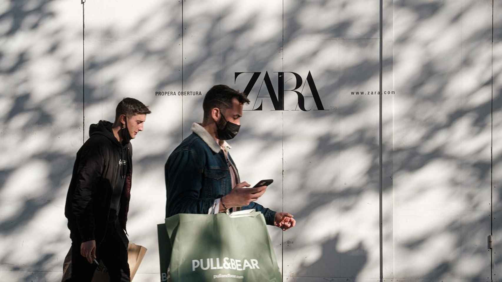 Dos hombres caminan delante de una tienda de Zara del Grupo Inditex en Barcelona / PABLO MIRANZO ( CG)