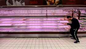 Un hombre coge productos refrigeradores en el supermercado, que experimenta picos de venta en gran consumo / EP