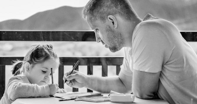 Un padre ayuda a su hija con los deberes / CG