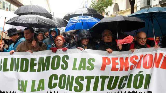 Varios asistentes a la manifestación por unas pensiones dignas convocada por la Mesa Estatal por el Blindaje de las Pensiones (MERP). Ni la lluvia enfría los ánimos de los pensionistas / EFE