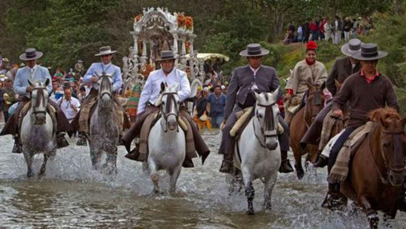 Un grupo de peregrinos cruzan un río a caballo, camino del Rocío / EFE