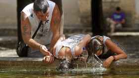 Unos turistas combaten el calor en una fuente de Córdoba en una imagen de archivo / EFE