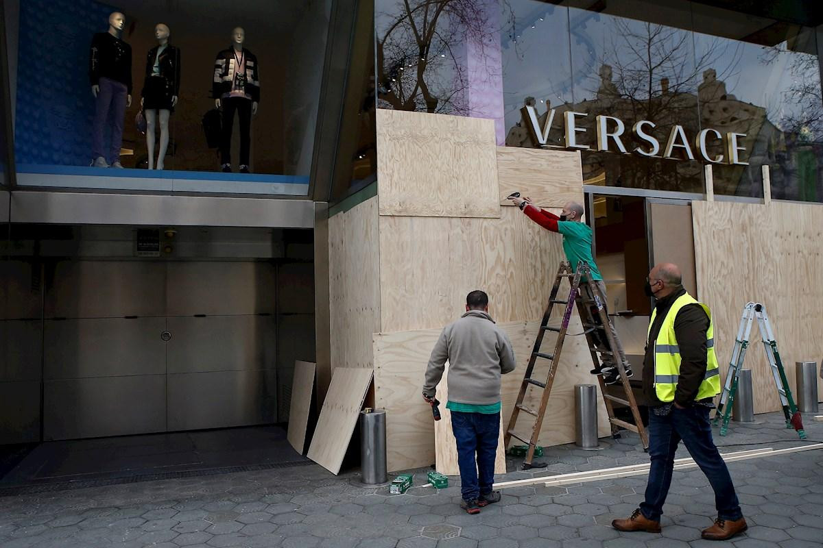 Los operarios reparan los destrozos de la tienda de Versace en Paseo de Gracia / EFE