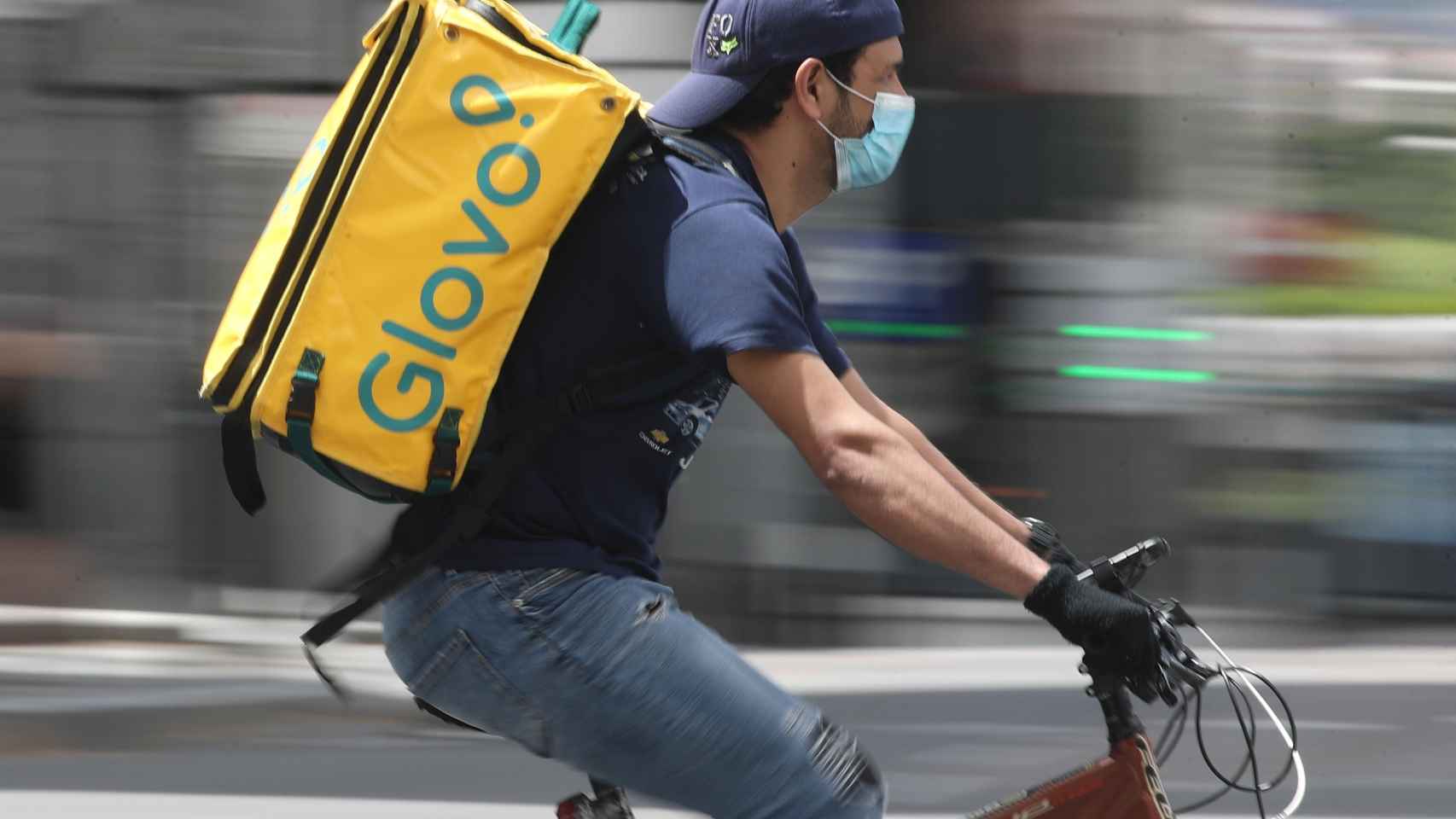 Un repartidor de Glovo monta una bicicleta durante su jornada laboral / EP