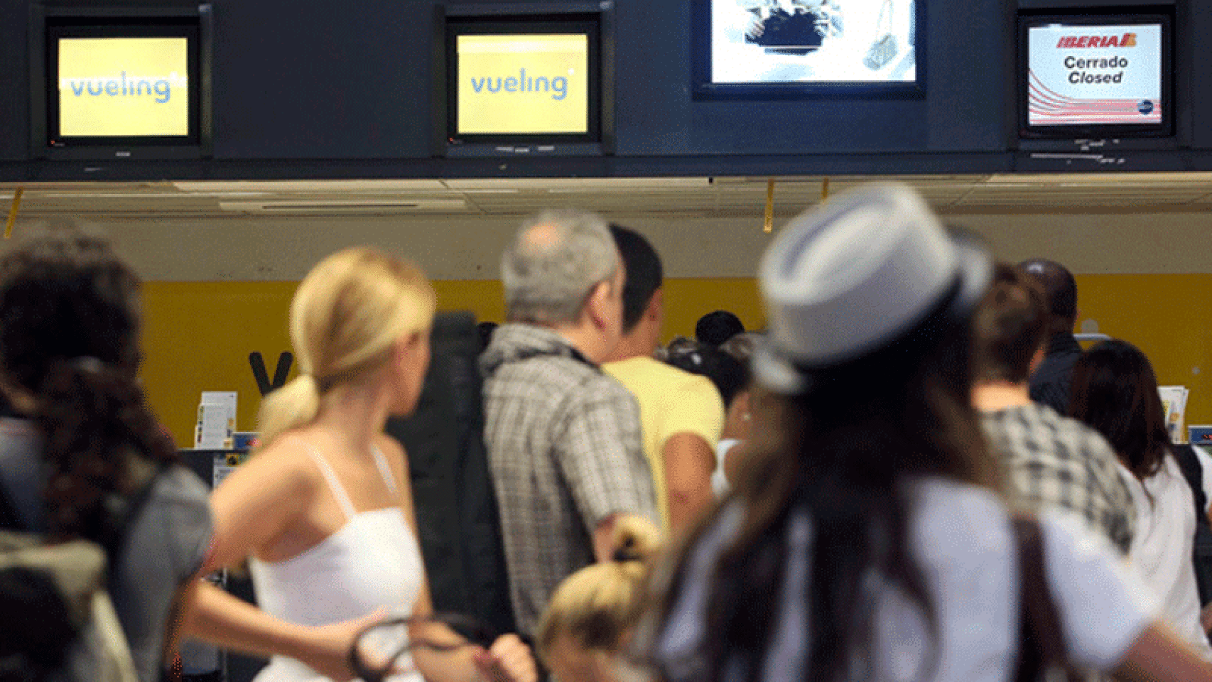 Varios pasajeros haciendo cola para facturar en Vueling