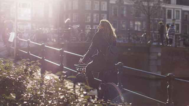 Una turista paseando en bicicleta por Ámsterdam / GENERATOR HOSTELS