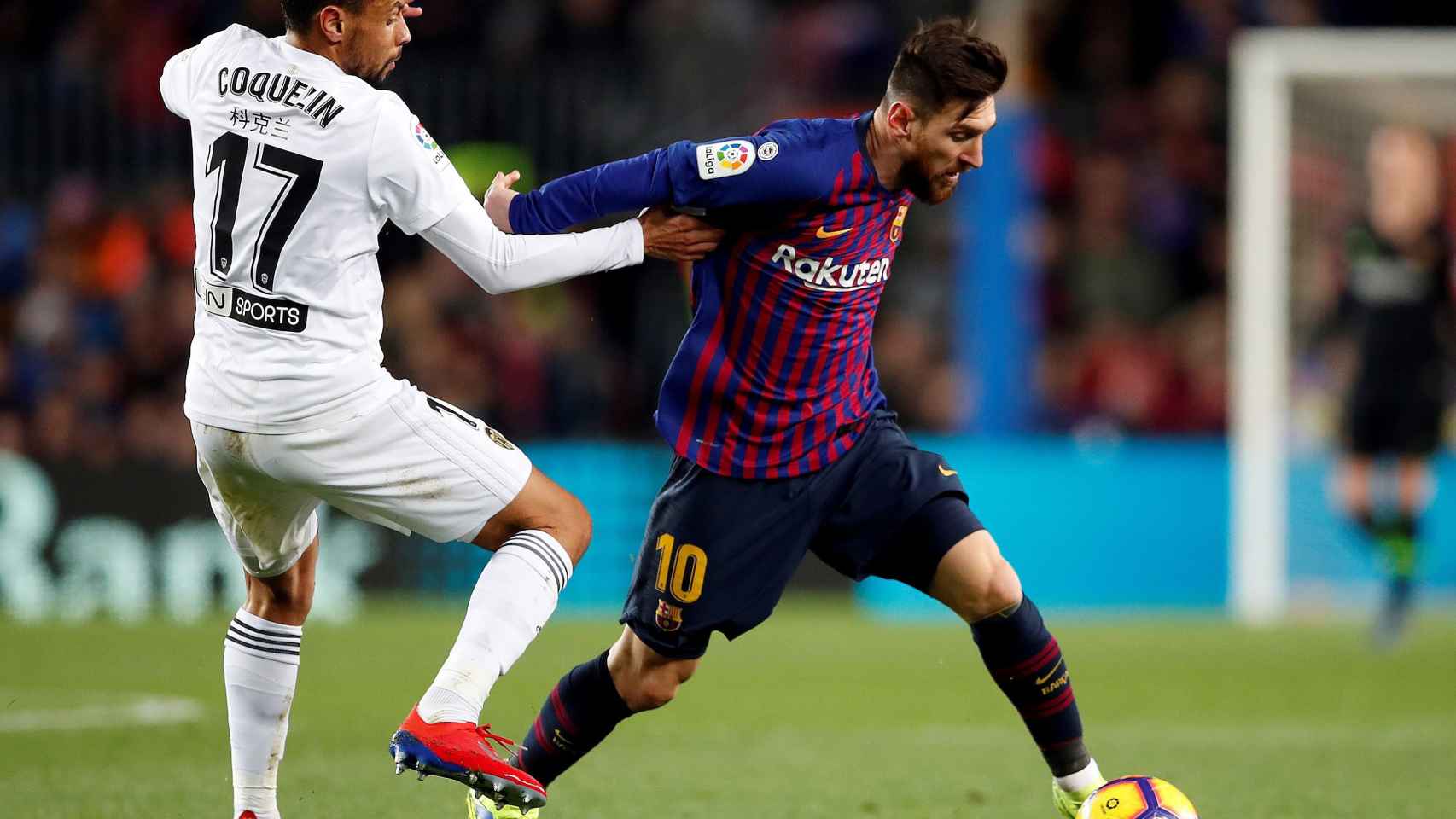 Leo Messi en una disputa con el jugador del Valencia Coquelin / EFE