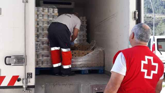Voluntarios de Cruz Roja cargan camiones con las donaciones de yogures de Danone / DANONE