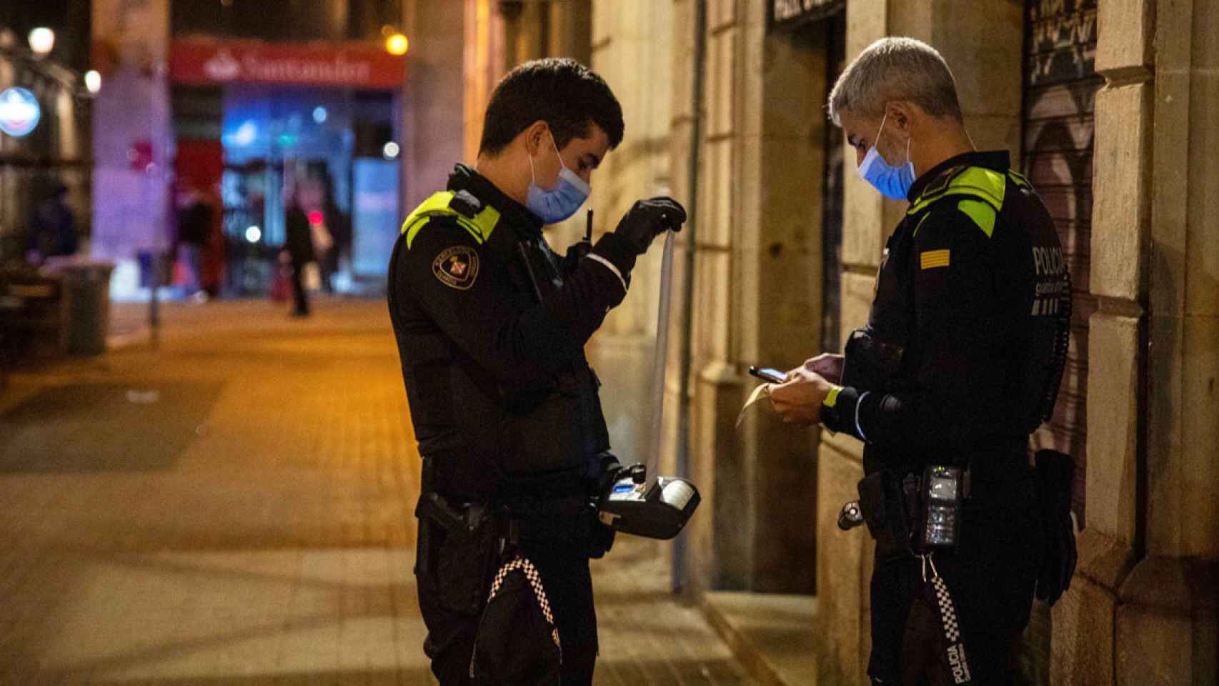 Dos agentes de la Guardia Urbana de Barcelona, sancionando por la pandemia / EP