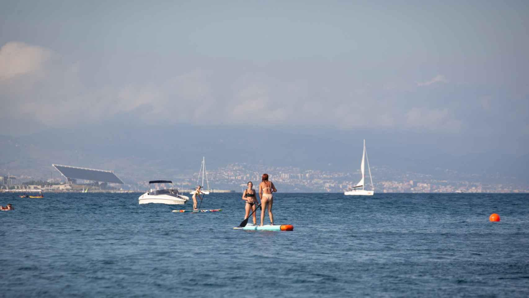 Dos mujeres practican 'paddle surf' en la playa de la Barceloneta / DAVID ZORRAKINO - EUROPA PRESS