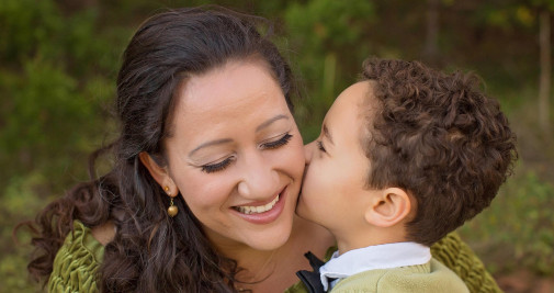 Un niño dándole un beso a su madre / PIXNIO