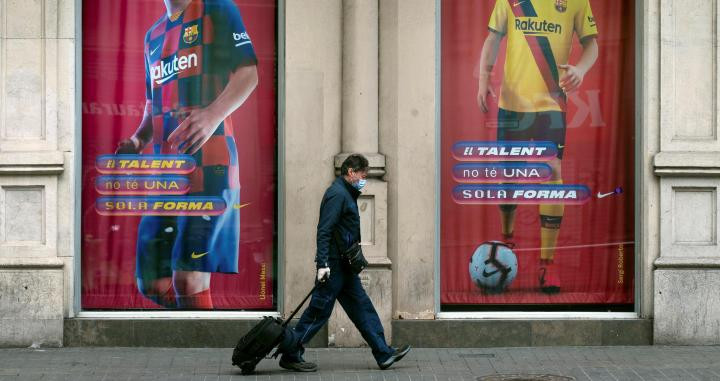 Un hombre pasa con una maleta por una calle de Barcelona / EFE