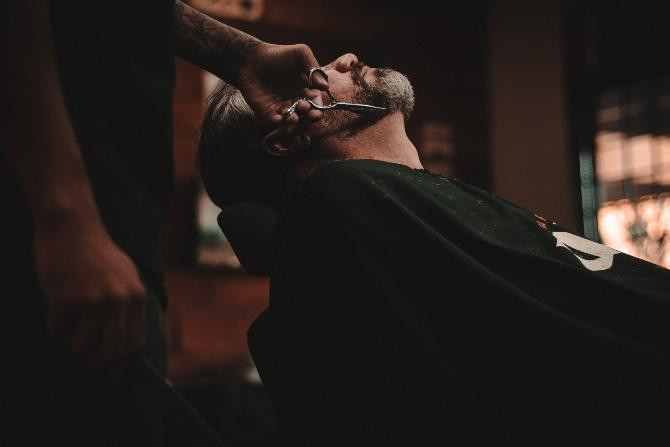 Profesional recortando la barba de un cliente / Allef Vinicius en UNSPLASH
