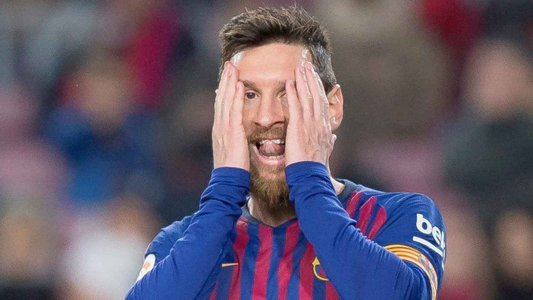 El delantero del FC Barcelona Leo Messi se toca la cara durante un partido en el Camp Nou / EFE