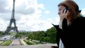Una chica llama por teléfono al lado de la Torre Eiffel / CG