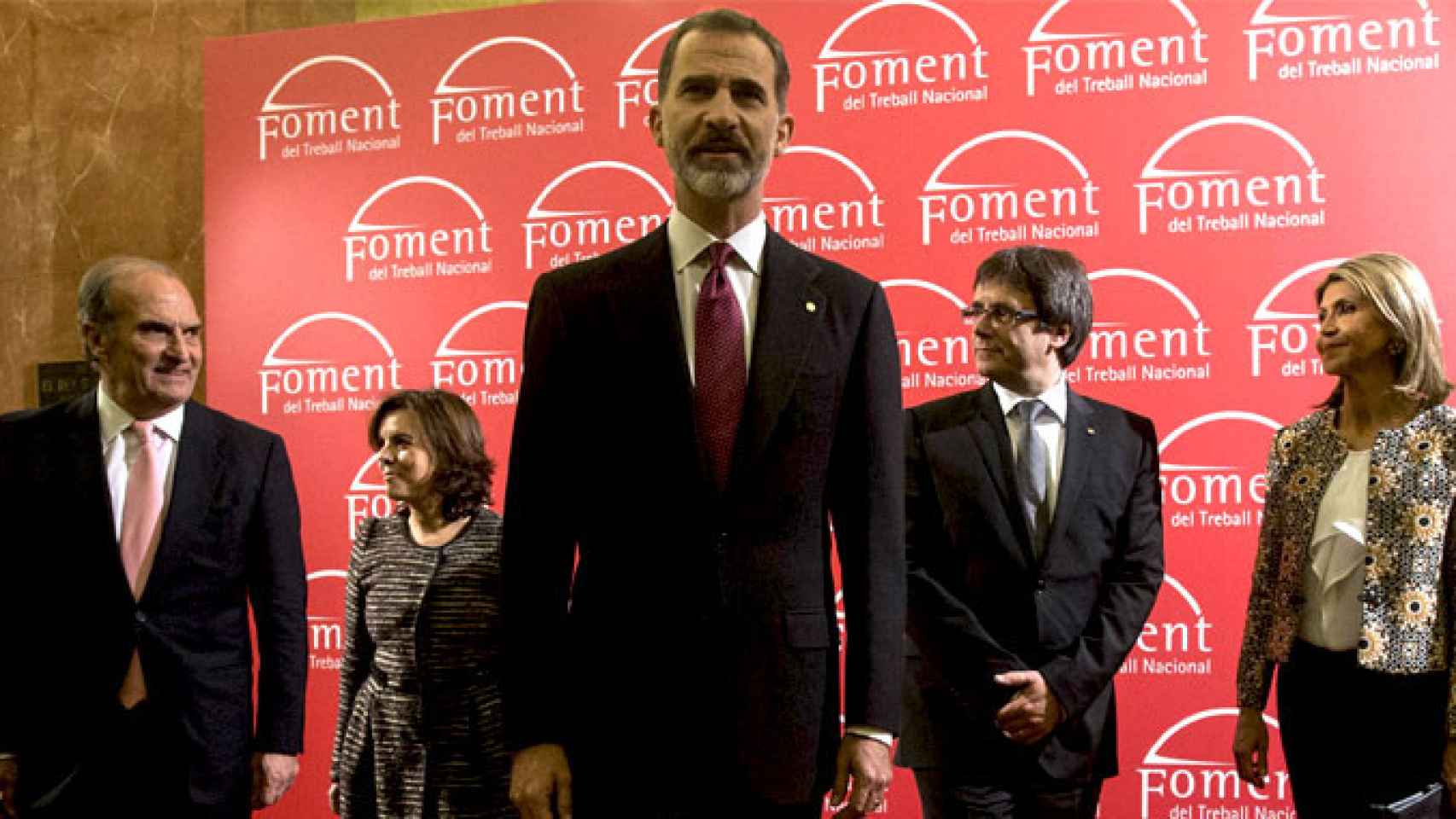 El rey Felipe VI (en el centro), en Foment del Treball junto al presidente de la patronal, Joaquim Gay de Montellà (i), la vicepresidenta del Gobierno, Soraya Sáenz de Santamaría (2i), el presidente de la Generalitat, Carles Puigdemont (2d) y la delegada
