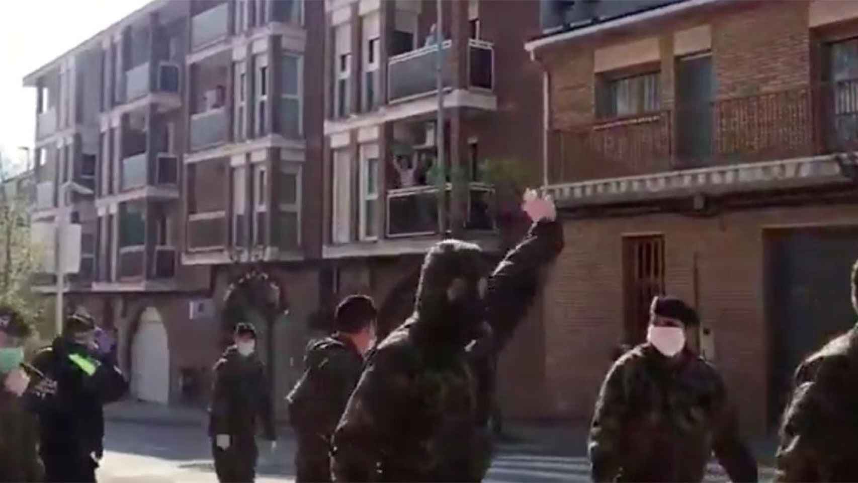 Miembros del Ejército saludan a los vecinos de Sant Joan de Vilatorrada (Barcelona) que les han aplaudido desde los balcones / CG
