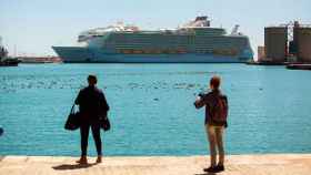 Dos turistas ven la llegada de un crucero en el puerto de Málaga esta Semana Santa / EFE