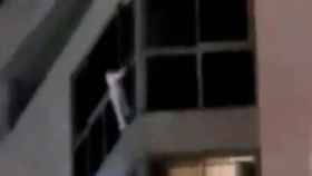 Imagen del vídeo que muestra a la niña colgada al balcón del séptimo piso de Alicante / CG