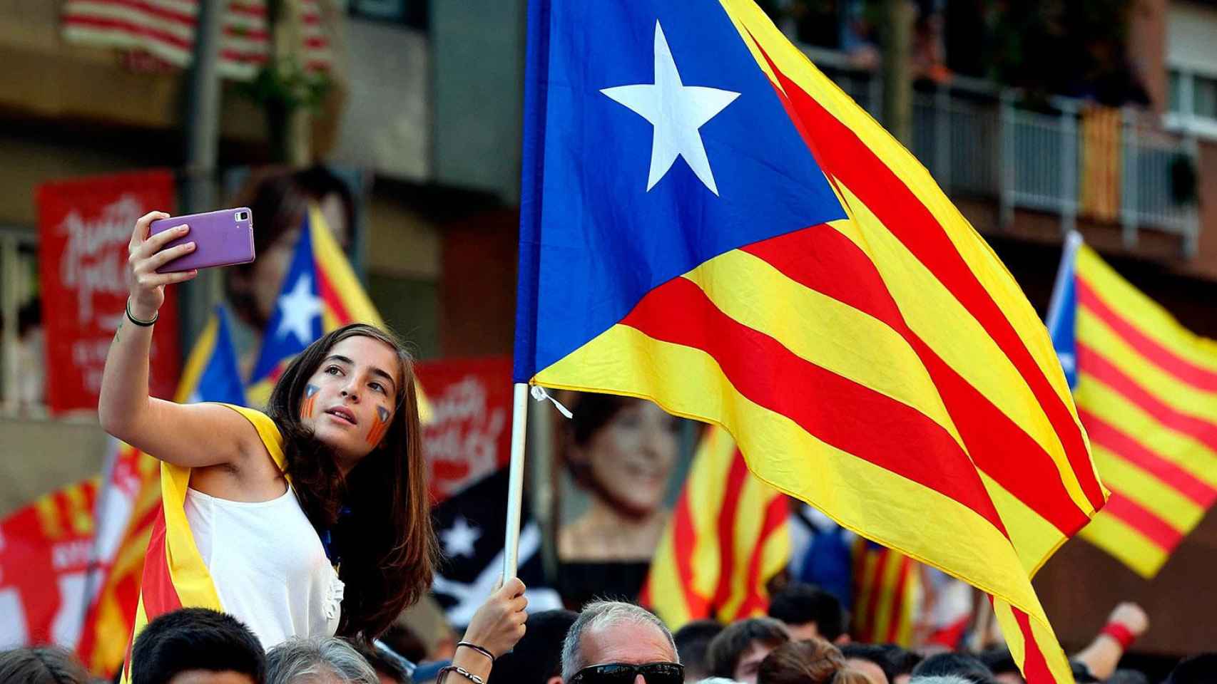 Una joven se hace una foto rodeada de banderas 'esteladas' en Cataluña / EFE