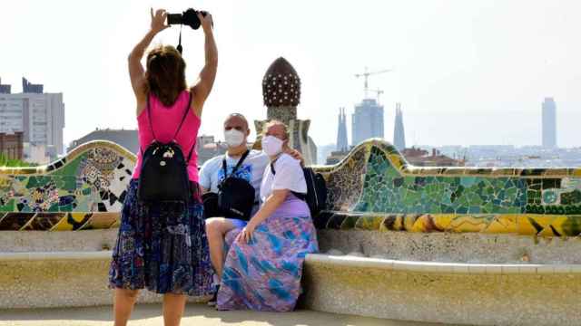 Tres turistas con mascarilla se hacen un selfi en el Parque Güell de Barcelona / EP