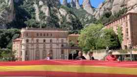 Peregrinos despliegan una bandera de España en el Monasterio de Montserrat / YOUTUBE