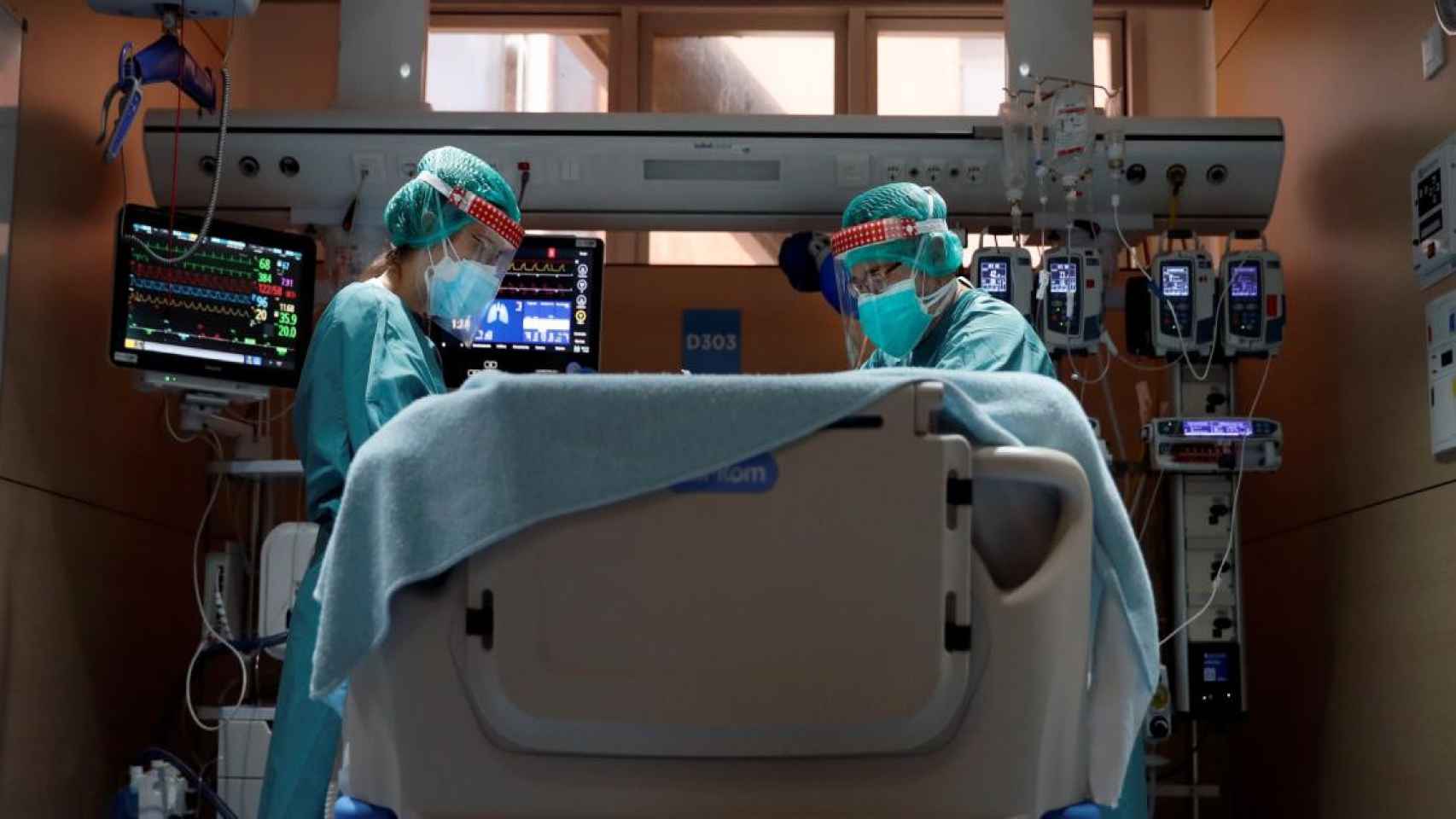 Mejora el riesgo de rebrote en Cataluña, pero aumenta la presión hospitalaria. En la imagen, dos profesionales sanitarios trabajan en la uci de Covid-19 del Hospital Vall d'Hebron de Barcelona / ALBERTO ESTÉVEZ - EFE