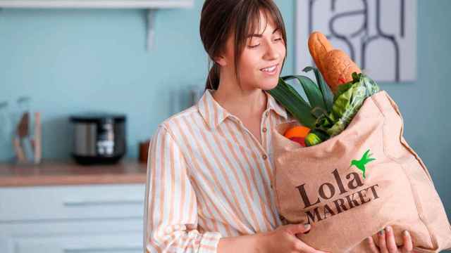 Una mujer recibe productos de supermercado de Lola Market en su hogar / ALIEXPRESS - LOLA MARKET