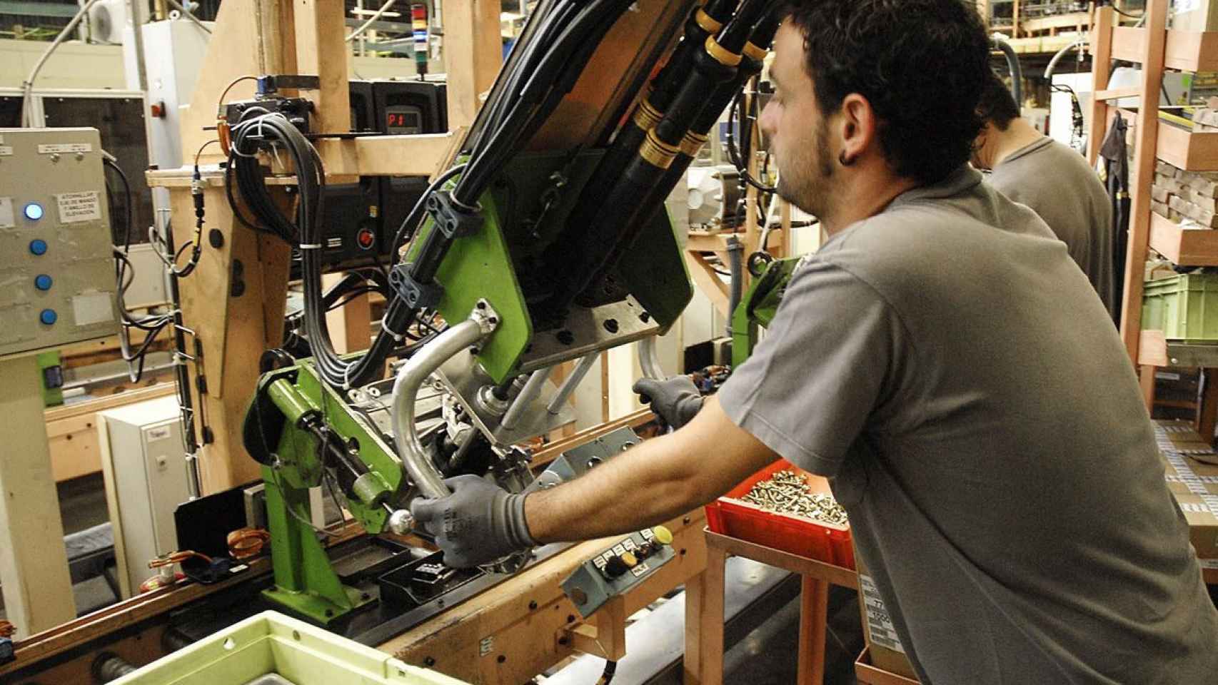 Un operario manipula una máquina en una fábrica de Sevilla. El paro sube en 57.257 personas / EFE