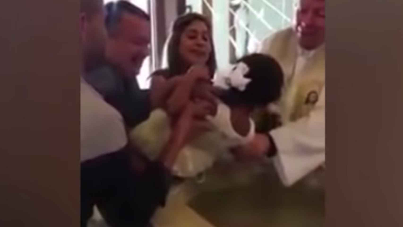 Una foto del momento en que el sacerdote bautiza a la niña