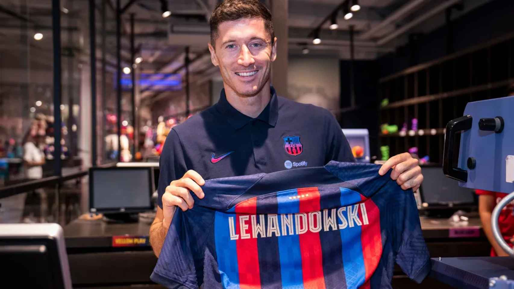 Lewandowski, posando su camiseta, en una sesión de fotos en la Barça Store / FCB