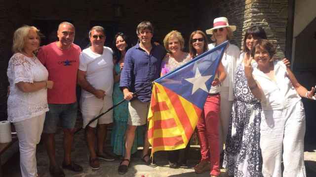 Carles Puigdemont, con una bandera estelada independentista en la mano junto a la tertuliana de TV3 Pilar Rahola y un grupo de amigos