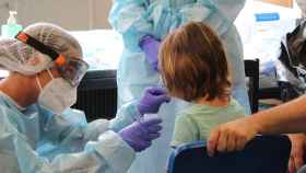 Una sanitaria realiza un test de anticuerpos en saliva a un niño para detectar Covid-19 / SANT JOAN DE DÉU
