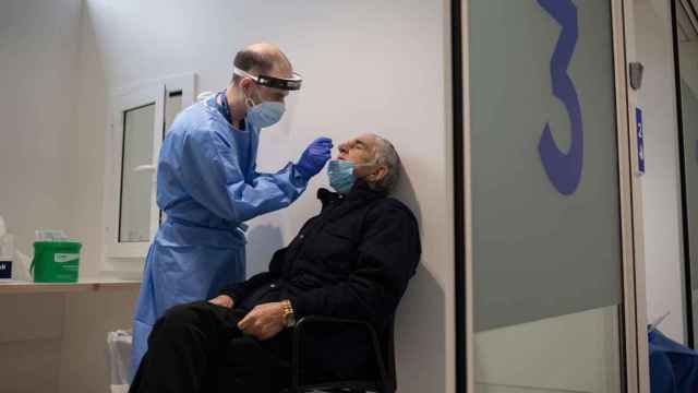 Un sanitario toma muestras de un paciente para hacer un test PCR / EP