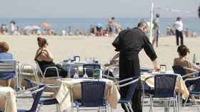 Un camarero sirve las mesas de la terraza de un restaurante en la playa / EFE