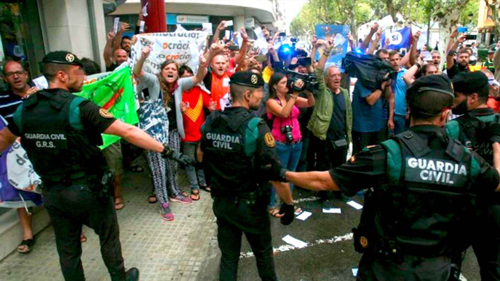 Guardias civiles ante un grupo de manifestantes, durante el registro del semanario El Vallenc / EFE