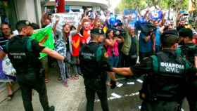 Guardias civiles ante un grupo de manifestantes, durante el registro del semanario El Vallenc / EFE