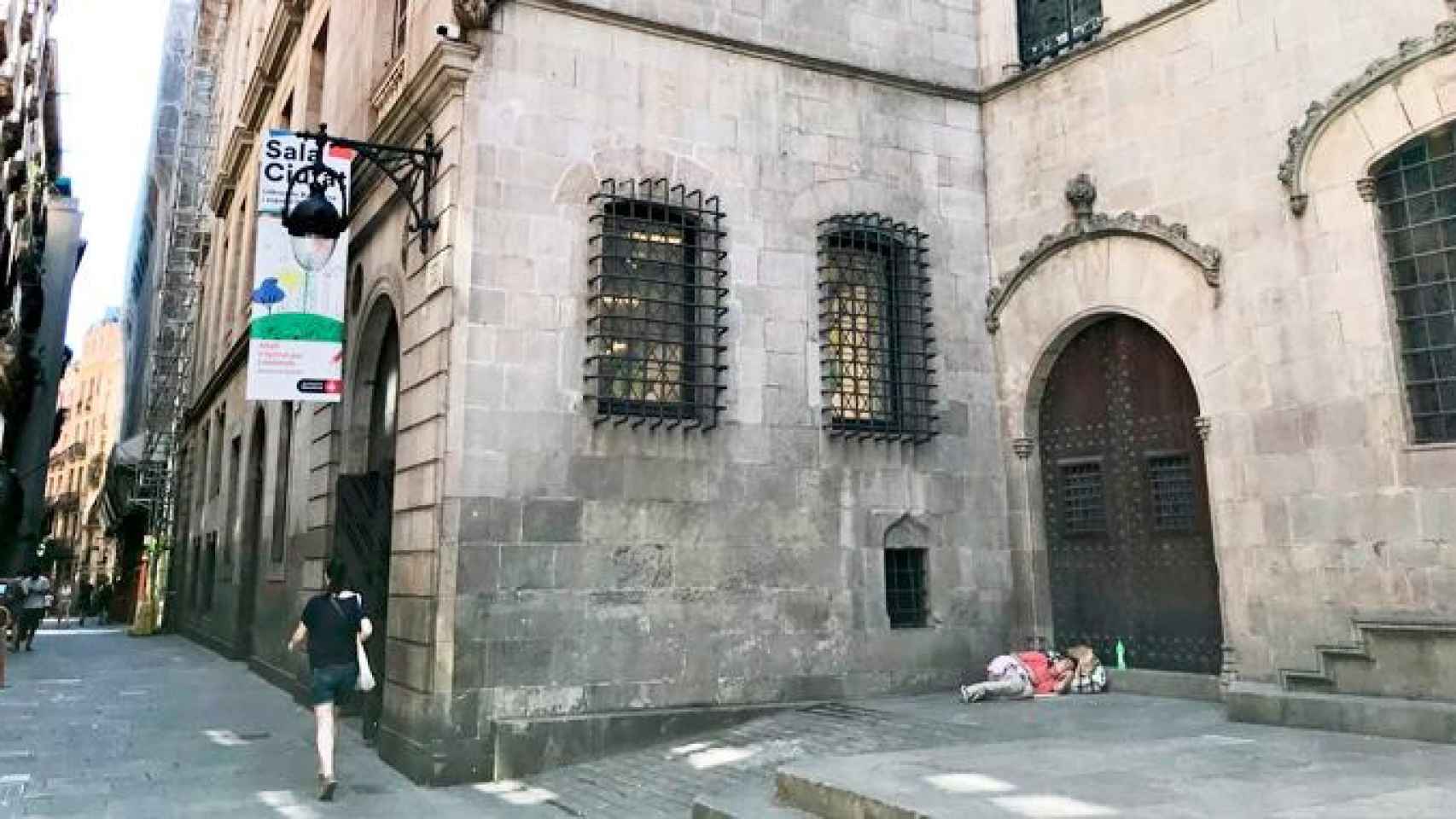 Imagen de la parte trasera del Ayuntamiento de Barcelona con una persona durmiendo en la calle / @mcrodes