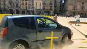 Un coche embiste las cruces amarillas plantadas en el suelo de una plaza de Vic / EFE