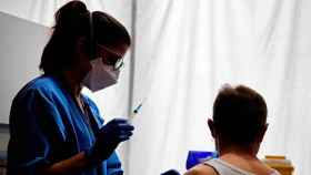 Una sanitaria administra una vacuna a una mujer en Barcelona / EFE