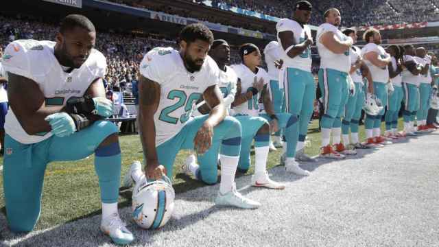 Jugadores del equipo de los Miami Dolphins se arrodillan mientras suena el himno nacional al inicio de su primer partido de la temporada / TWITTER