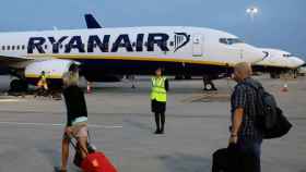 Dos pasajeros de Ryanair se dirigen a un avión de la aerolínea con dos maletas de mano / EFE