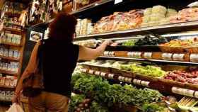 Imagen de archivo de una mujer cogiendo productos en un supermercado, compras que se reflejan en el consumo interno del país / EFE