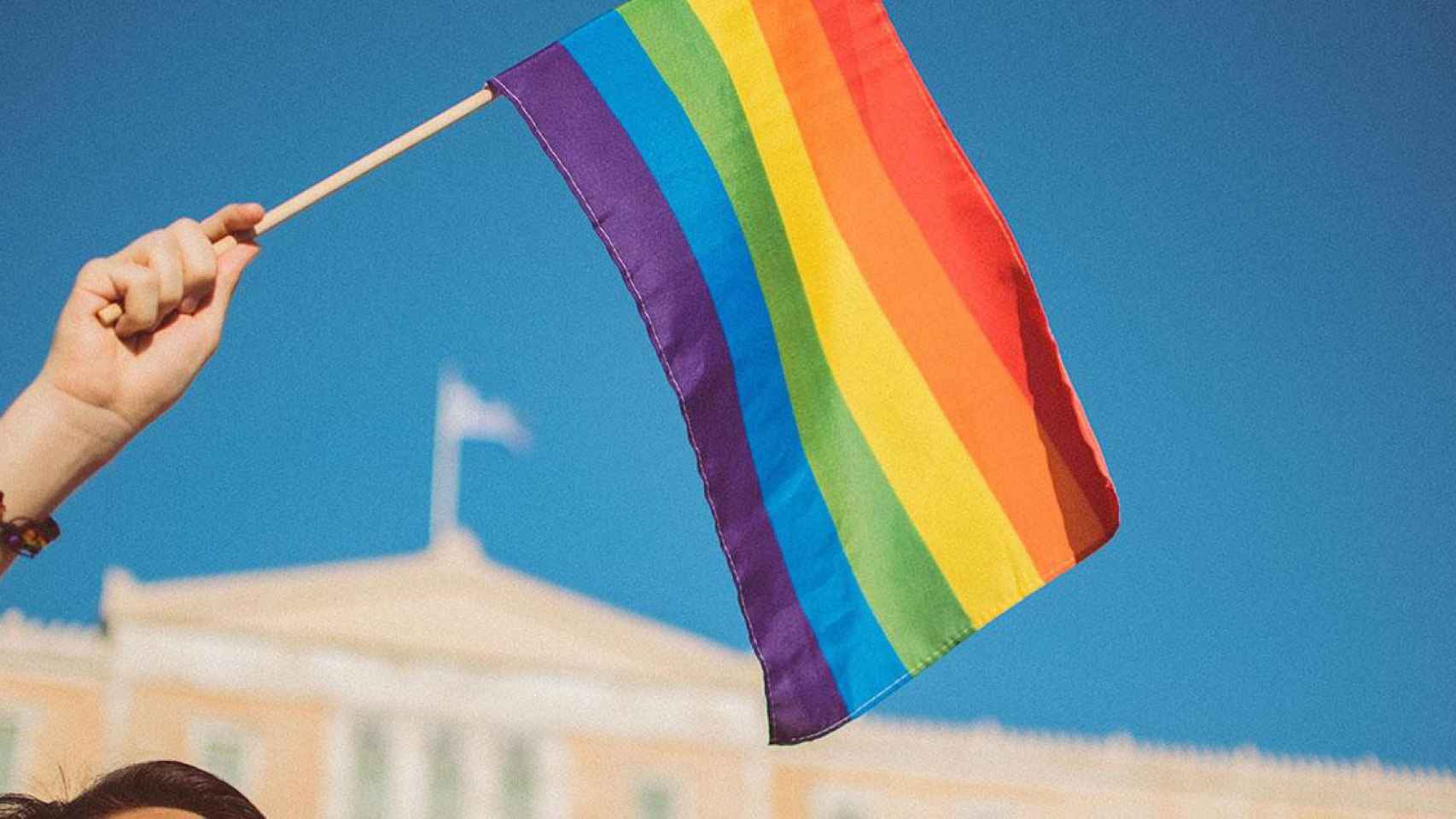 Una persona agita una bandera LGTBI / UNSPLASH - Stavrialena Gontzou