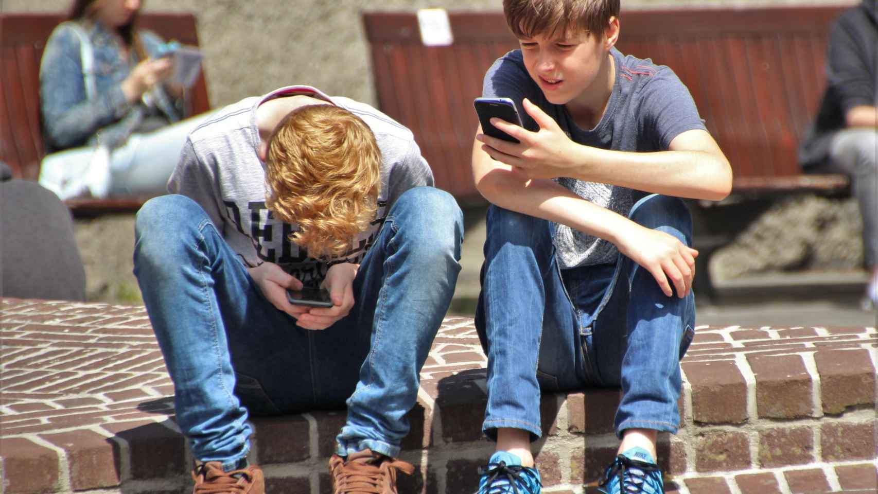 Dos chicos pegados a su teléfono móvil / PEXELS