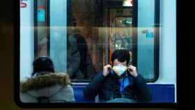 Un pasajero tapándose la cara con una mascarilla contra el virus en el Metro de Barcelona / CG