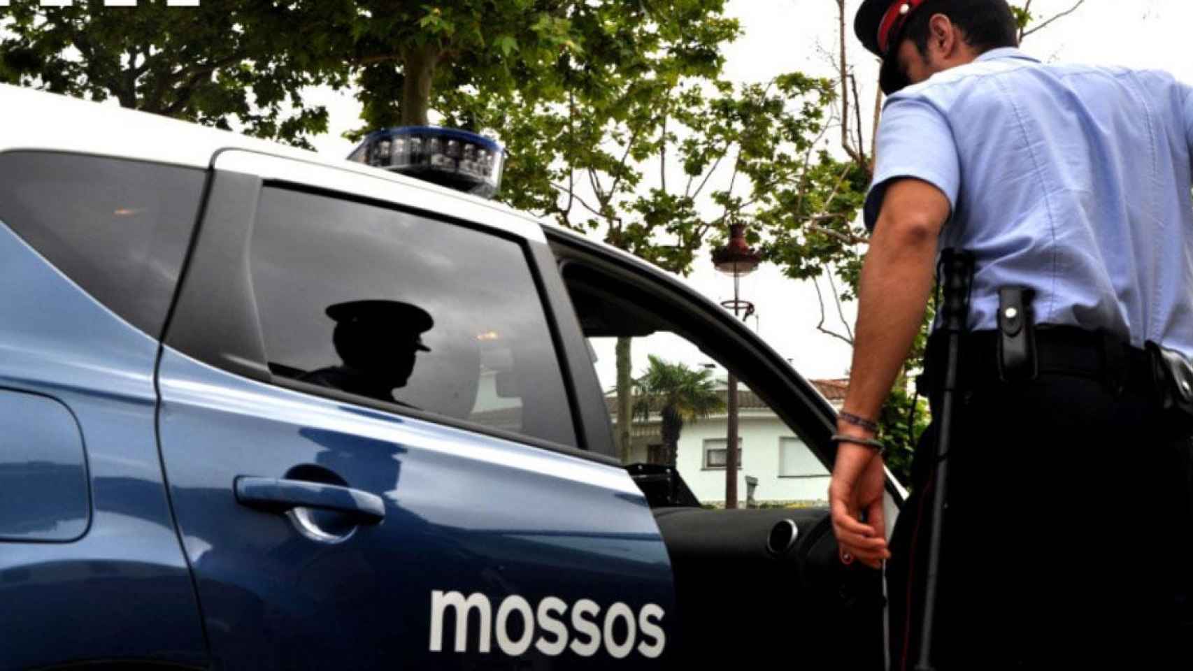 Un agente de Mossos d'Esquadra entra en un coche patrulla / MOSSOS