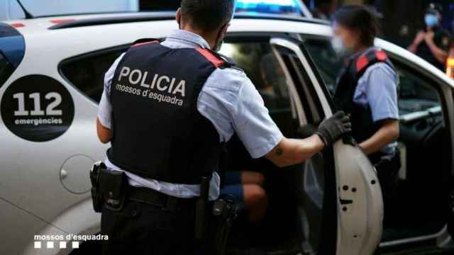 Agentes de Mossos meten a una persona detenida en el coche para trasladarla a comisaría / MOSSOS